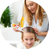 Ein Mädchen bekommt die Haare von Ihrer Mutter mit dem mosquito Läuse 2 in 1 Fluid behandelt.